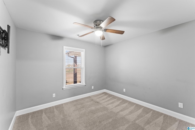 spare room with baseboards, carpet flooring, and a ceiling fan