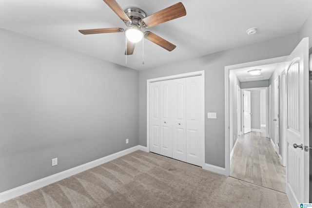 unfurnished bedroom with carpet floors, baseboards, ceiling fan, and a closet