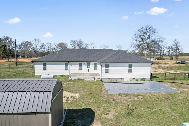 rear view of house with a patio area, crawl space, fence, and a lawn