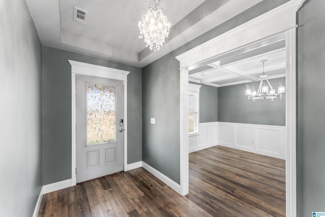 entryway with visible vents, a chandelier, hardwood / wood-style floors, coffered ceiling, and wainscoting
