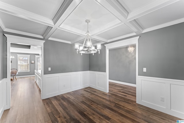unfurnished dining area with coffered ceiling, dark wood-style flooring, beamed ceiling, a notable chandelier, and wainscoting