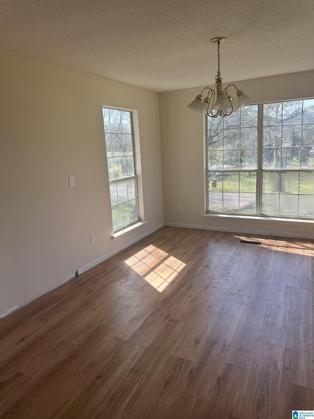 3825 County Road 715, Cullman, AL 35055 - empty room with baseboards, a notable chandelier, wood finished floors, and a textured ceiling