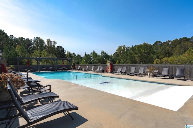 community pool with a patio area, a pergola, and fence