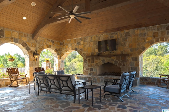 view of patio / terrace with ceiling fan, fence, an outdoor stone fireplace, and outdoor dining area