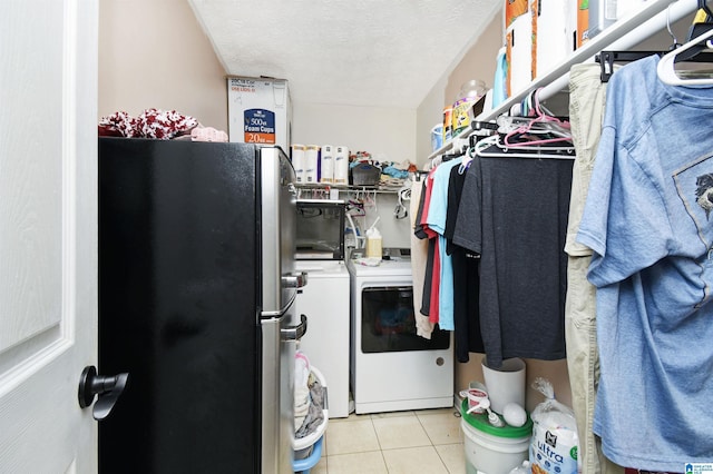 laundry area featuring independent washer and dryer, light tile patterned floors, laundry area, and a textured ceiling