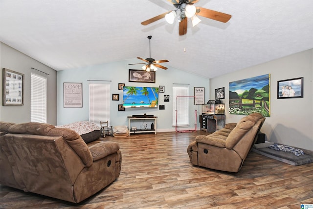 living area featuring lofted ceiling, baseboards, a textured ceiling, a ceiling fan, and wood finished floors