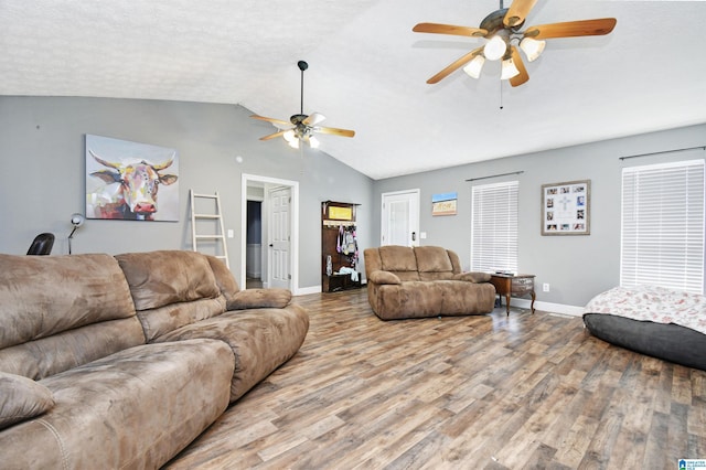 living room with vaulted ceiling, a ceiling fan, wood finished floors, a textured ceiling, and baseboards