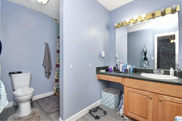 full bath with toilet, vanity, and baseboards