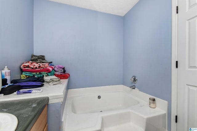 full bathroom with vanity and a bath