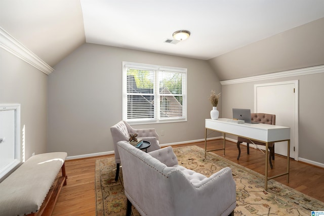 office area featuring visible vents, baseboards, vaulted ceiling, and wood finished floors