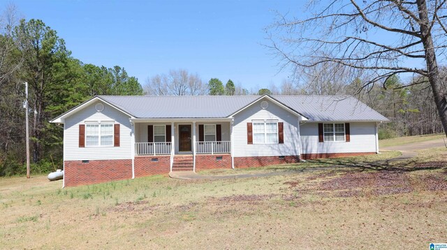 ranch-style home featuring covered porch, a front yard, crawl space, and metal roof