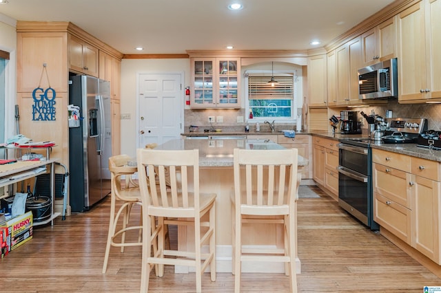 881 Ridgeway Cir, Talladega, AL 35160 - kitchen with a sink, decorative backsplash, light brown cabinetry, and stainless steel appliances