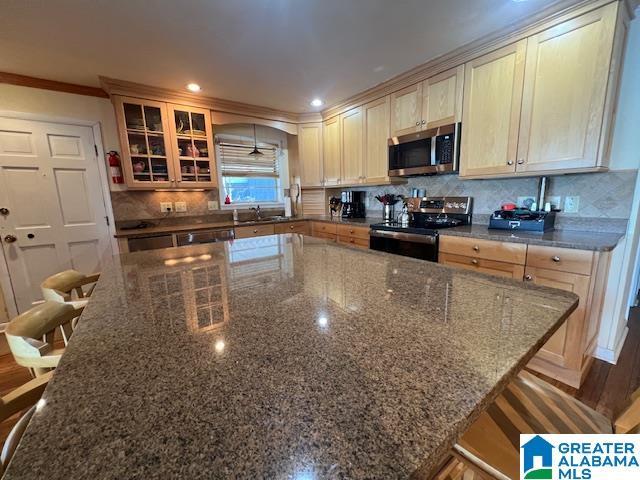 881 Ridgeway Cir, Talladega, AL 35160 - kitchen featuring ornamental molding, stainless steel appliances, tasteful backsplash, glass insert cabinets, and a sink