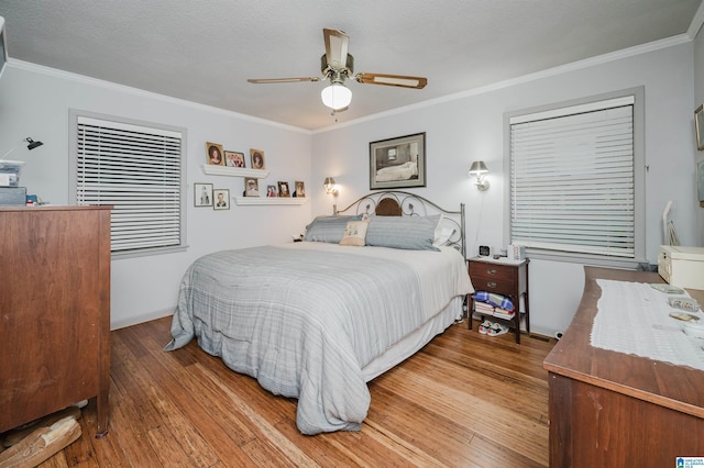 881 Ridgeway Cir, Talladega, AL 35160 - bedroom with crown molding, hardwood / wood-style flooring, a ceiling fan, a textured ceiling, and baseboards