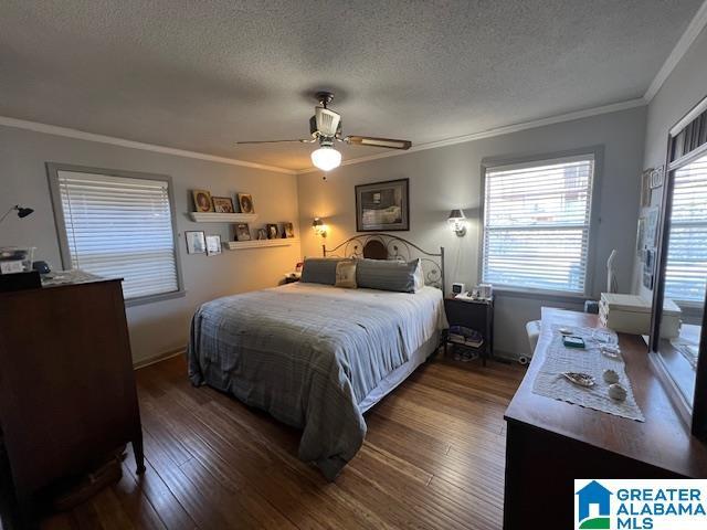 881 Ridgeway Cir, Talladega, AL 35160 - bedroom featuring dark wood-type flooring, a textured ceiling, ornamental molding, and ceiling fan