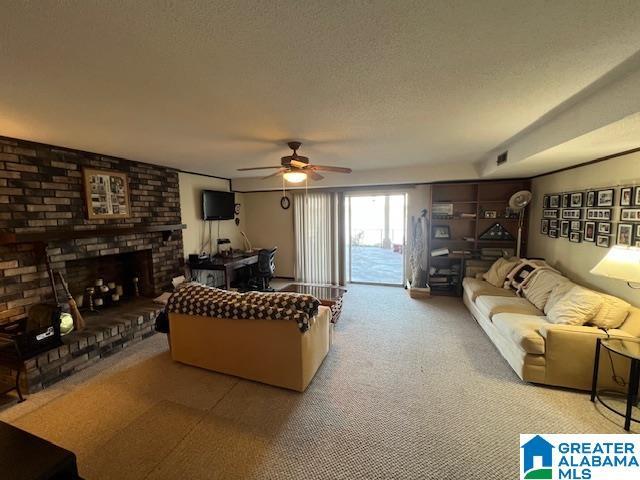 881 Ridgeway Cir, Talladega, AL 35160 - living room with a brick fireplace, visible vents, ceiling fan, and a textured ceiling