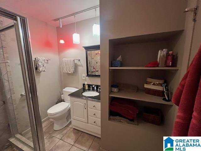 881 Ridgeway Cir, Talladega, AL 35160 - full bath featuring tile patterned floors, toilet, a stall shower, and vanity