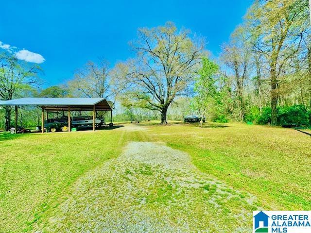 view of property's community featuring a lawn, driveway, and a carport