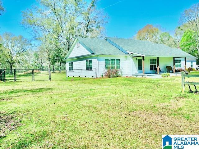 rear view of property with fence and a yard