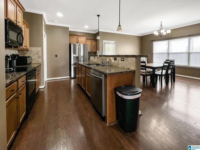 kitchen featuring a sink, brown cabinetry, black appliances, and an inviting chandelier