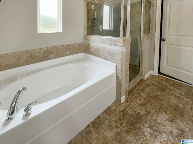 bathroom featuring a bath and a stall shower