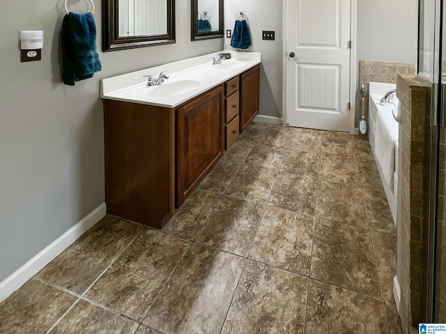 bathroom featuring a bath, double vanity, a sink, and baseboards