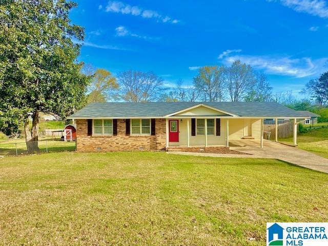 ranch-style home with a front yard, an attached carport, and fence