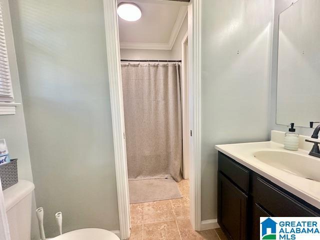 bathroom with curtained shower, crown molding, toilet, and vanity