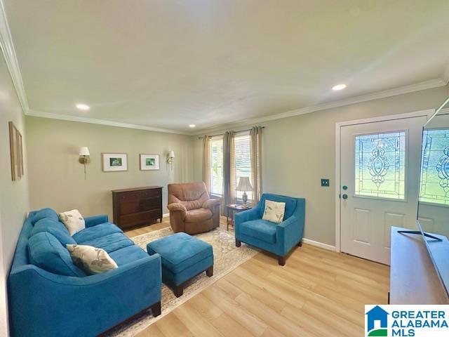 living area with baseboards, ornamental molding, recessed lighting, and light wood-style floors