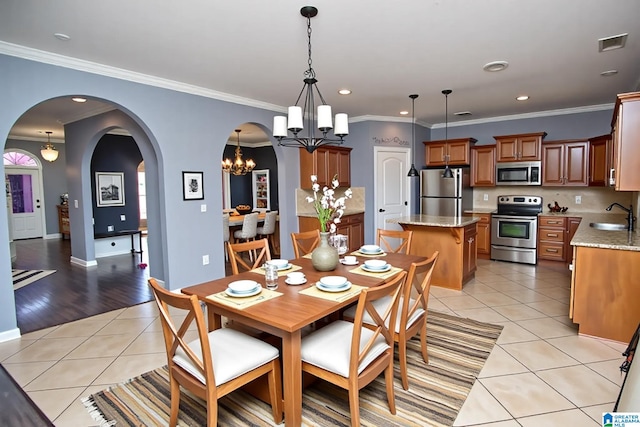 8014 Waterford Dr, Pinson, AL 35126 - dining space with light tile patterned floors, arched walkways, an inviting chandelier, and recessed lighting