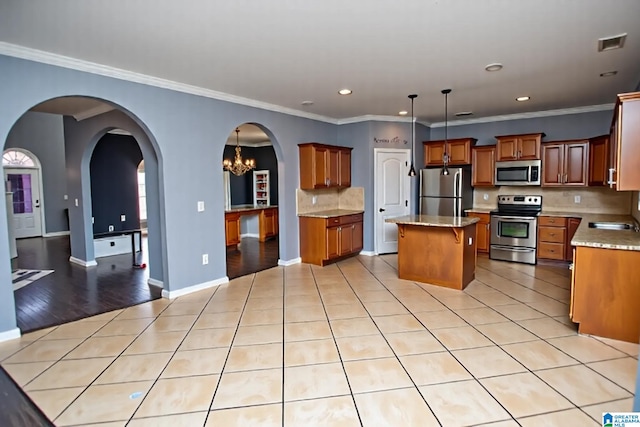 8014 Waterford Dr, Pinson, AL 35126 - kitchen with a kitchen island, backsplash, brown cabinets, stainless steel appliances, and recessed lighting