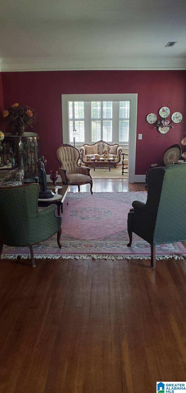 living room featuring visible vents, crown molding, and wood finished floors