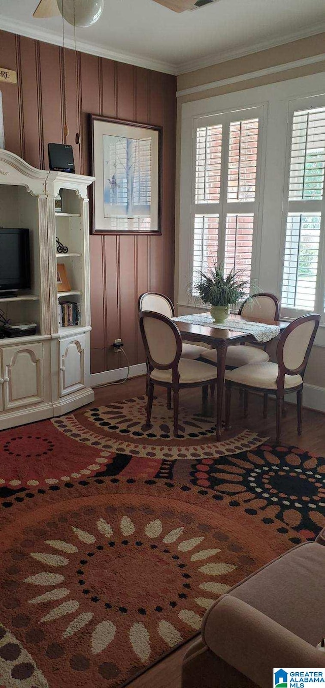dining space with ornamental molding and wood finished floors