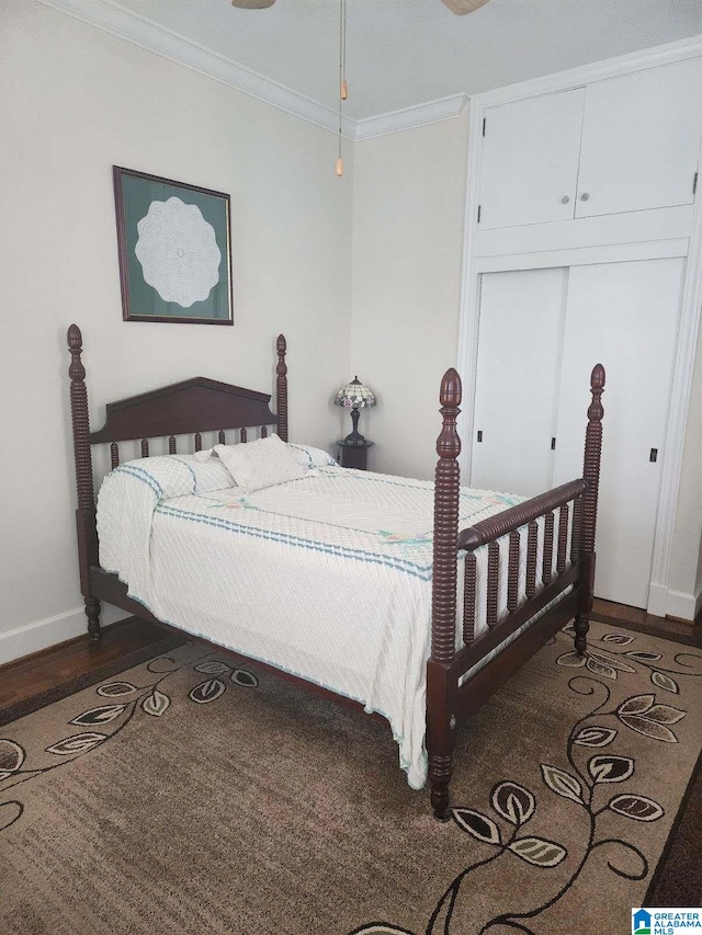 bedroom featuring a closet, crown molding, baseboards, and wood finished floors