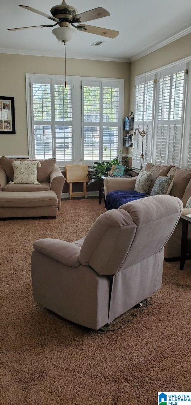 living area with a ceiling fan, ornamental molding, carpet, and visible vents