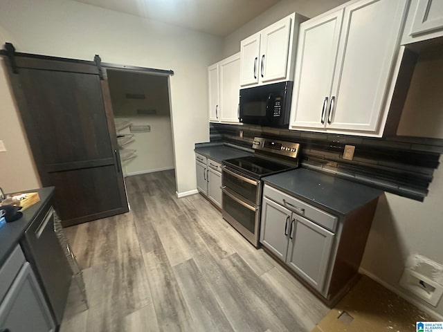 6777 Southern Trace Cir, Leeds, AL 35094 - kitchen with light wood finished floors, tasteful backsplash, dark countertops, range with two ovens, and black microwave