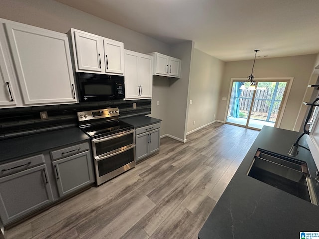 6777 Southern Trace Cir, Leeds, AL 35094 - kitchen featuring light wood finished floors, a sink, dark countertops, range with two ovens, and black microwave