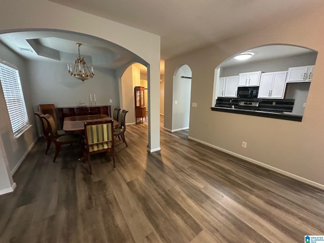6777 Southern Trace Cir, Leeds, AL 35094 - dining area featuring baseboards, arched walkways, a chandelier, and dark wood finished floors