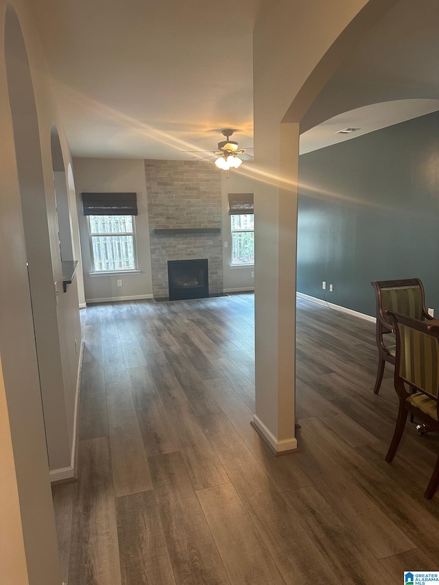 6777 Southern Trace Cir, Leeds, AL 35094 - unfurnished living room featuring ceiling fan, arched walkways, a healthy amount of sunlight, and baseboards