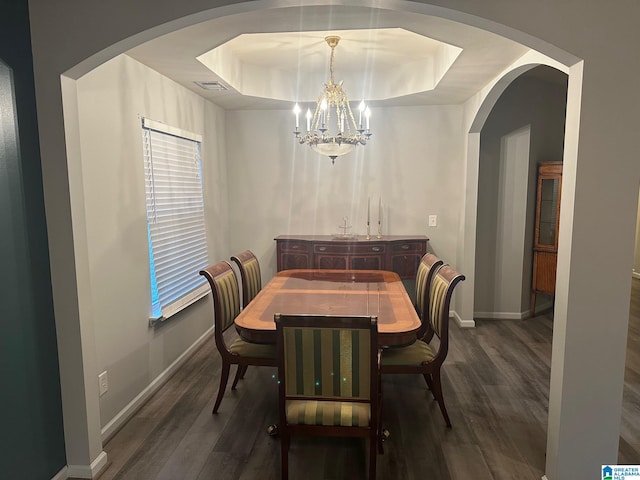 6777 Southern Trace Cir, Leeds, AL 35094 - dining area featuring a raised ceiling, wood finished floors, visible vents, and a notable chandelier