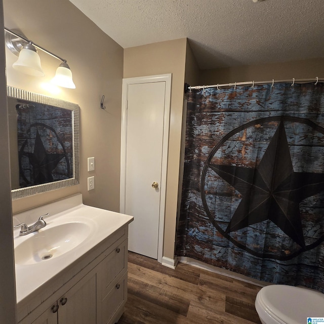 full bathroom with a shower with curtain, vanity, toilet, a textured ceiling, and wood finished floors