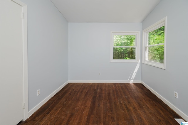 unfurnished room with visible vents, baseboards, and dark wood finished floors