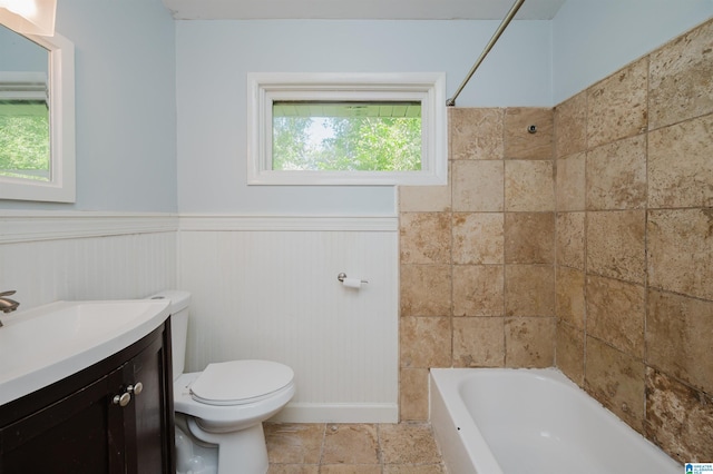 bathroom with toilet, shower / tub combination, vanity, and a wainscoted wall