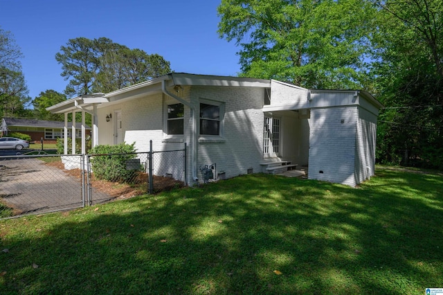 exterior space with crawl space, a yard, entry steps, fence, and brick siding
