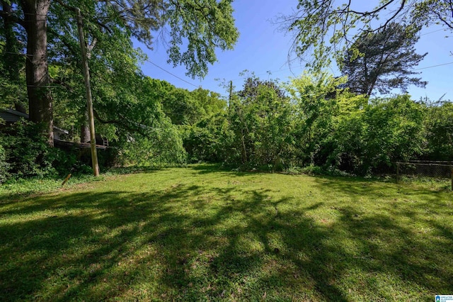 view of yard featuring a view of trees and fence