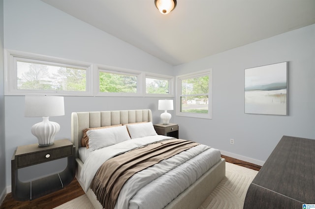 bedroom featuring wood finished floors, baseboards, and lofted ceiling