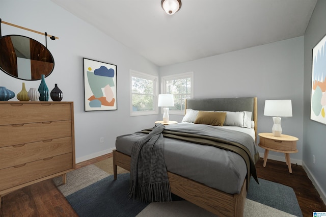 bedroom featuring baseboards, wood finished floors, and vaulted ceiling