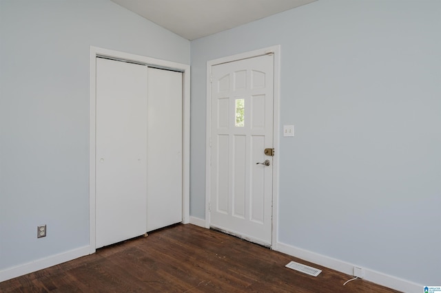 foyer with visible vents, baseboards, and dark wood finished floors