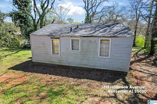 exterior space with a yard and roof with shingles