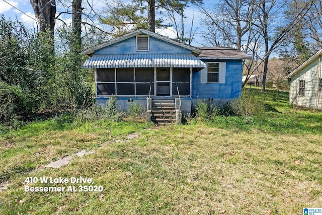 rear view of property featuring a lawn and a sunroom